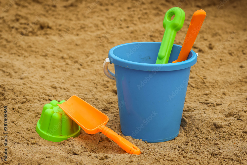 Children's beach sand toys. Kids concept. Plastic children's toys. Blue bucket, colorful molds. Children's beach sand toys. Kids concept. Plastic children's toys. Blue bucket, colorful molds.