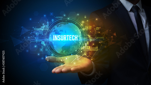 Elegant hand holding INSURTECH inscription, digital technology concept