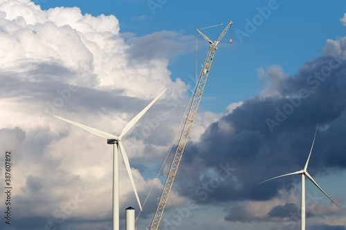wind turbines and a crane with a dramatic sky background