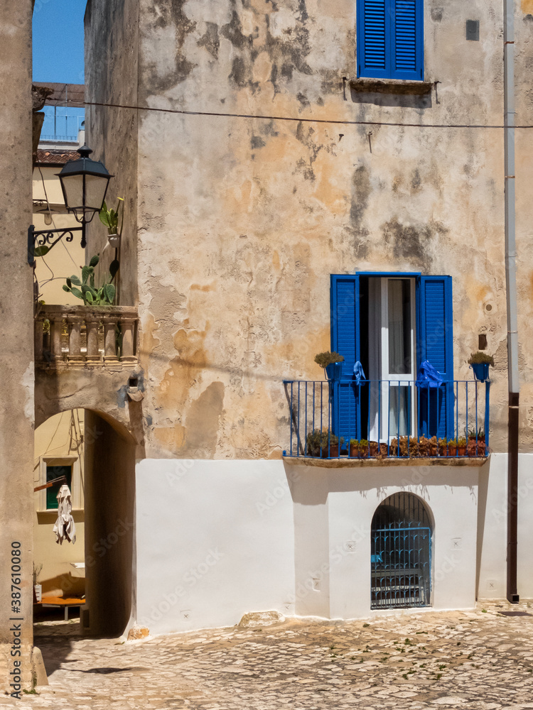 Small square and house with blue shutters in Otranto (Puglia, Italy) downtown.