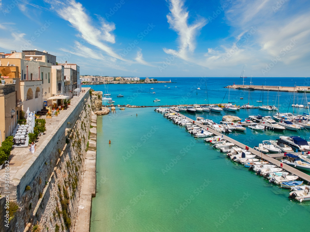 Tourist port under the ancient walls of Otranto (Puglia, Italy) overlooking a crystalline sea.