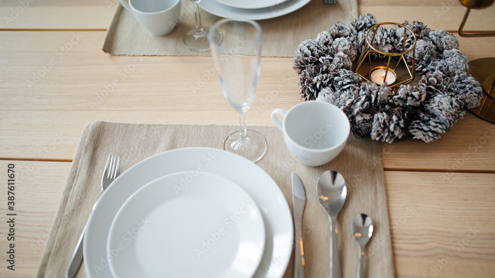 New Year's table setting. Christmas wreath, candles, tree. Beautiful festive interior New Year's table setting. Christmas wreath, candles, tree. Beautiful festive interior
