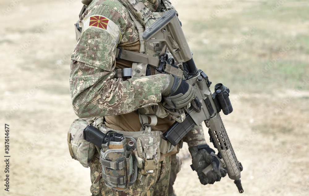 Fototapeta premium Soldier with assault rifle and flag of North Macedonia on military uniform. Collage.