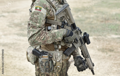 Canvas Print Soldier with assault rifle and flag of Myanmar and also known as Burma on military uniform