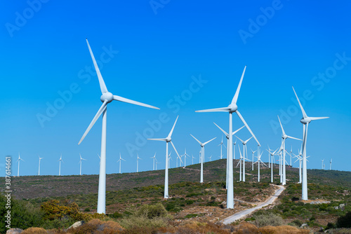 Aerial view large group of eco system wind turbines power generation station on green field in rural landscape in countryside