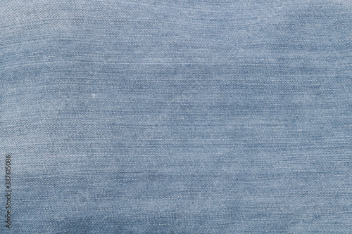 Textured background of blue denim jeans with seam and thread stitch. 