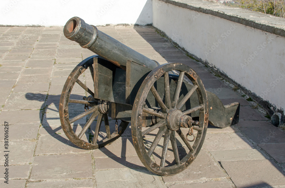 Old metal cannon on the wall of the fortress.