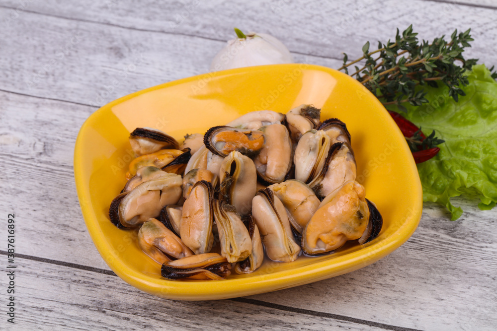 Pickled mussels in the bowl served pepper, garlic and salad Pickled mussels in the bowl served pepper, garlic and salad