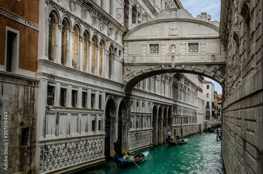 Famous Bridge of Sighs with gondolas. The enclosed bridge is made of white limestone connect Doge's Palace and new prison.
