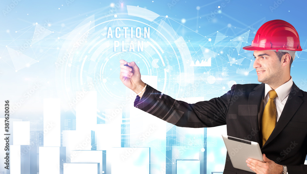 Handsome businessman with helmet drawing ACTION PLAN inscription, contruction business concept