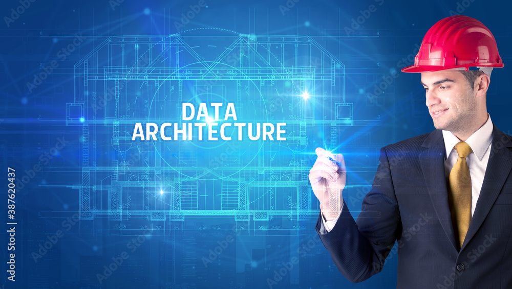 Handsome architect with helmet drawing DATA ARCHITECTURE inscription, new technology concept Handsome architect with helmet drawing DATA ARCHITECTURE inscription, new technology concept