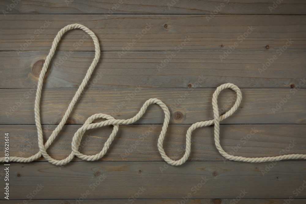 love realizado con cuerda en un fondo de listones de madera love realizado con cuerda en un fondo de listones de madera