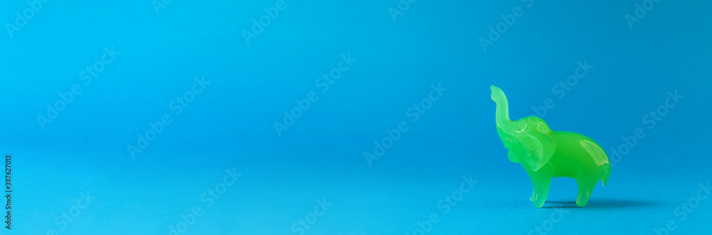 A jasper elephant is walking on a blue background. A jasper elephant is walking on a blue background.