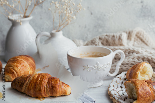 Fototapeta Naklejka Na Ścianę i Meble -  Delicious breakfast with fresh croissants and cup of coffee on a white wooden background. Delicious Baking