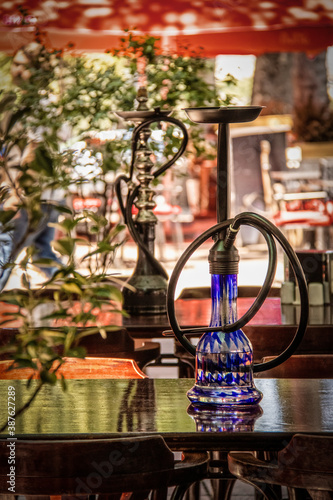 Waterpipe or  hookah or shisha for tobacco smoking on table of sidewalk cafe in Bohemian Tbilisi Georgia  - Selective focus with reflctions photo