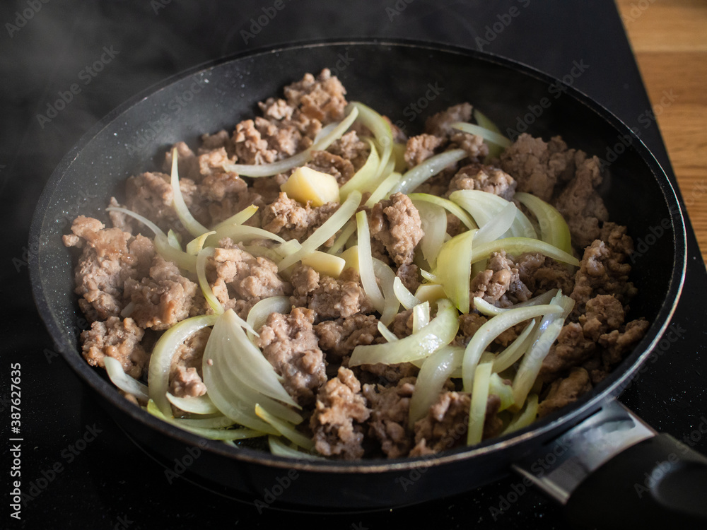 Pork nuggets frying in pan with white onion
Pork nuggets frying in pan with white onion