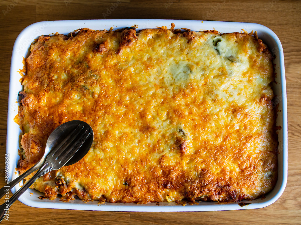 Noodle casserole with minced meat, mozzarella cheese and vegetables on wooden table
 - obrazy, fototapety, plakaty 