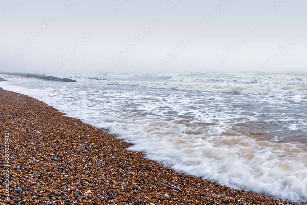 Ocean waves on a pebble beach. Ocean waves on a pebble beach.