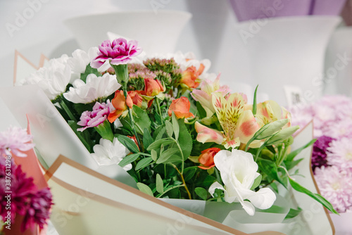 Fototapeta Naklejka Na Ścianę i Meble -  Flower shop concept. Close-up beautiful lovely bouquet of mixed flowers on wooden table.