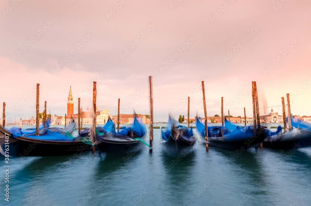 Gondolas moored by Saint Mark square with San Giorgio di Maggiore church background at sunset in Venice, Italy. Gondolas moored by Saint Mark square with San Giorgio di Maggiore church background at sunset in Venice, Italy.