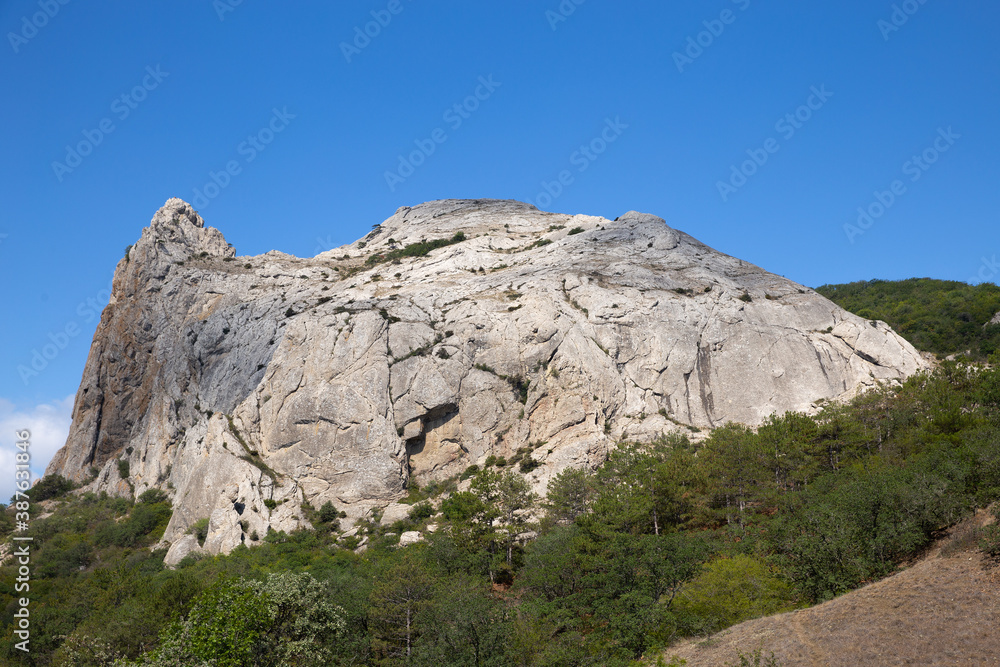 White rock. View of the white rock against the blue sky and green forest. Great place for rock climbers