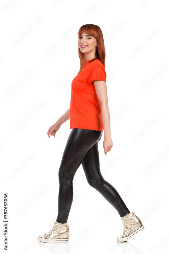 Fototapeta premium Smiling Young Woman Is Walking And Looking At Camera