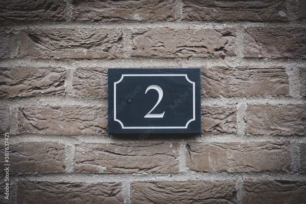 Isolated view of a newly installed, slate Number 2 sign seen outside a town house. Isolated view of a newly installed, slate Number 2 sign seen outside a town house.