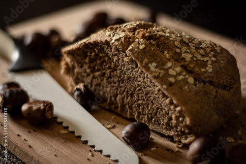 Autumn still life with homemade wheat bread and chestnuts on a wooden cutting board