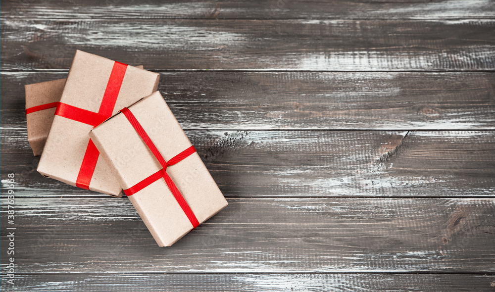 Three gifts on a gray wooden background.
Three gifts on a gray wooden background.