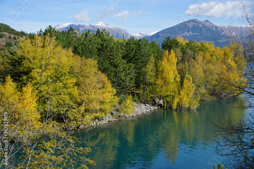 mirror reflection of trees in the fall in Serre Ponçon lake, France