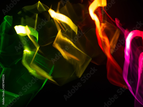 light painting photography, waves of vibrant color against a black background. Long exposure photo of vibrant fairy lights in abstract © SergeyKatyshkin