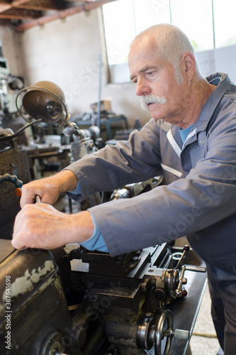 a senior engineer repairing machinery © auremar