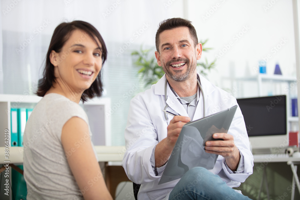 portrait of cheerul male doctor with female patient portrait of cheerul male doctor with female patient