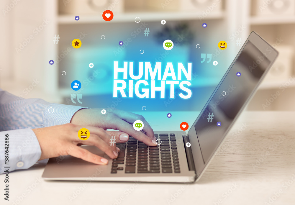 Freelance woman using laptop with HUMAN RIGHTS inscription, Social media concept Freelance woman using laptop with HUMAN RIGHTS inscription, Social media concept