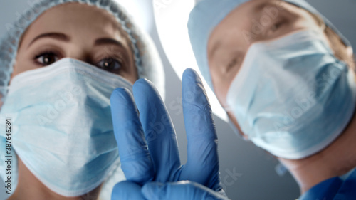 Professional medical doctors working in emergency medicine. Portrait of the surgeon and the nurse in protective masks performing surgical operation.
