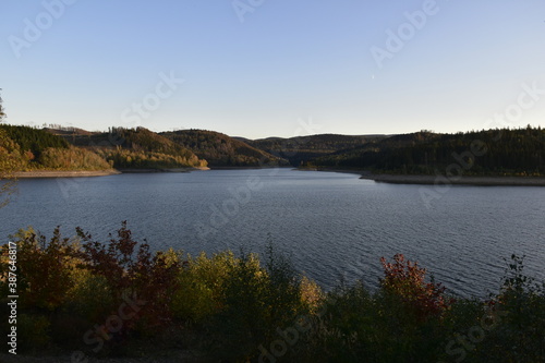 Stausee bei Goslar in Abendsonne und Mond am Himmel