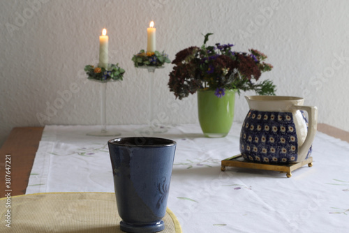 table with cup, mug, flowers and candles