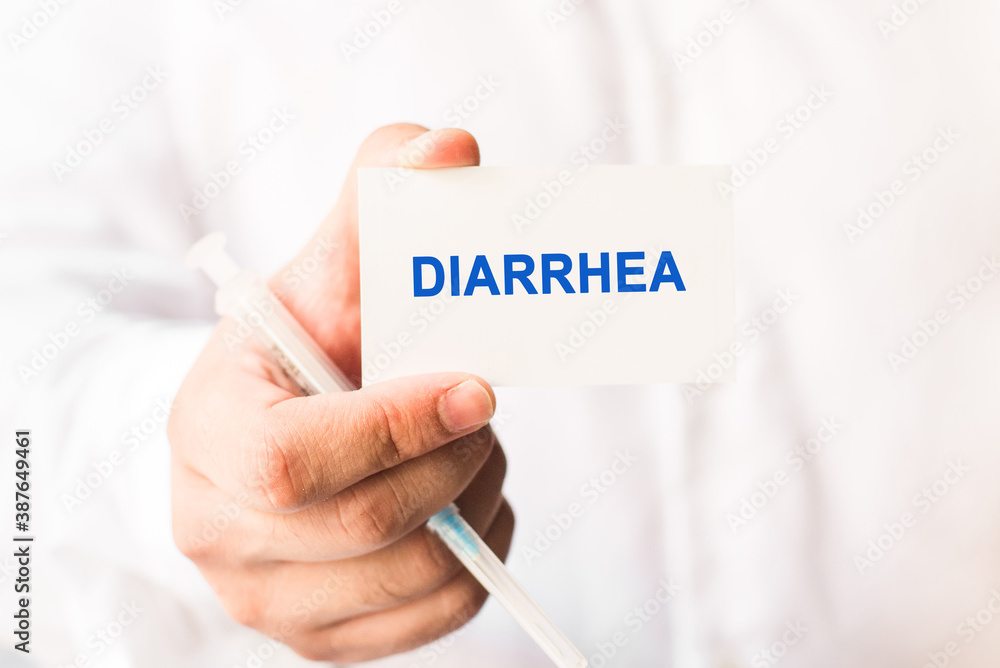 Word diarrhea on a white background with a syringe in hand. Medicine and healthcare concept Word diarrhea on a white background with a syringe in hand. Medicine and healthcare concept