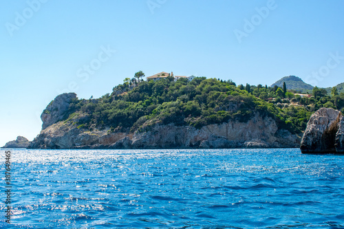 A view of a monastery atop a cliff in Palaiokastritsa, Corfu, as seen from a boat