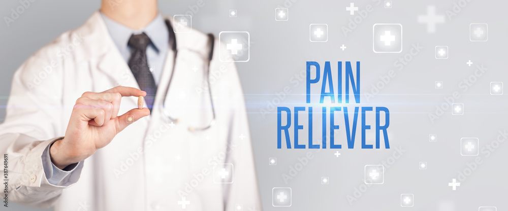 Close-up of a doctor giving a pill with PAIN RELIEVER inscription, medical concept