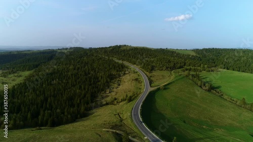 Mountain road. Spring. Route no H13 Ukraine. Coniferous forest in Europe. 
Aerial view of evening sunset. Travel on vacation photo