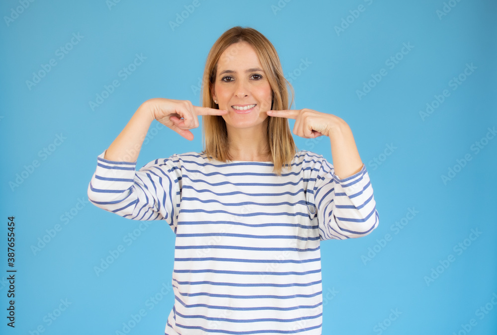 pretty young woman pointing her mouth over blue background. pretty young woman pointing her mouth over blue background.