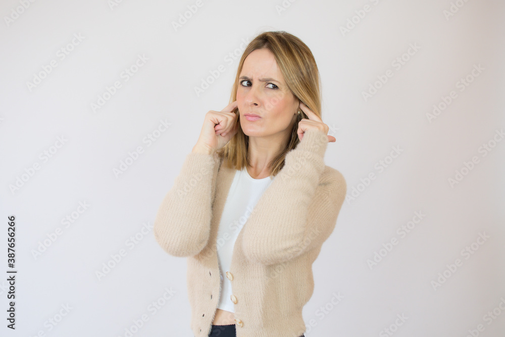 Beautiful woman covering her ears isolated on a white background Beautiful woman covering her ears isolated on a white background