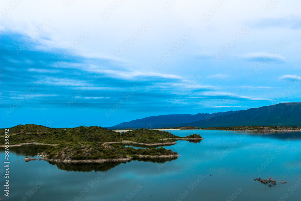 Vista de unas pequeñas islas de tierra rodeadas por un lago junto a las montañas