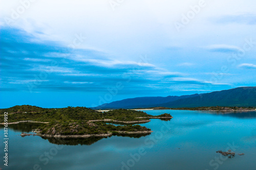 Vista de unas pequeñas islas de tierra rodeadas por un lago junto a las montañas © Pablo