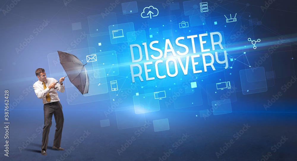 Businessman defending with umbrella from cyber attack and DISASTER RECOVERY inscription, online security concept Businessman defending with umbrella from cyber attack and DISASTER RECOVERY inscription, online security concept