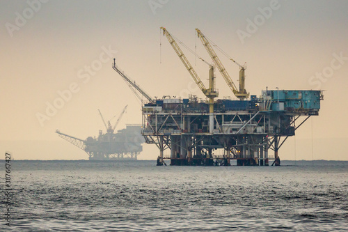 Obraz na płótnie A pair of offshore oil wells off the coast of California during sunrise. w salonie