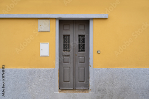 Lisbon, Portugal: yellow wall with grey wooden door