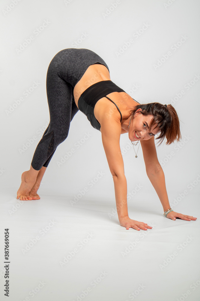 Obraz premium beautiful brunette is engaged in yoga in the studio on a white background