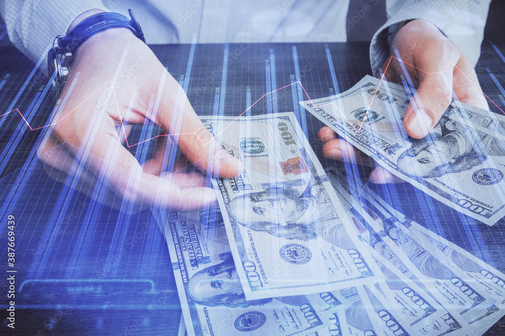 Multi exposure of financial graph drawing hologram and USA dollars bills and man hands. Analysis concept. Multi exposure of financial graph drawing hologram and USA dollars bills and man hands. Analysis concept.